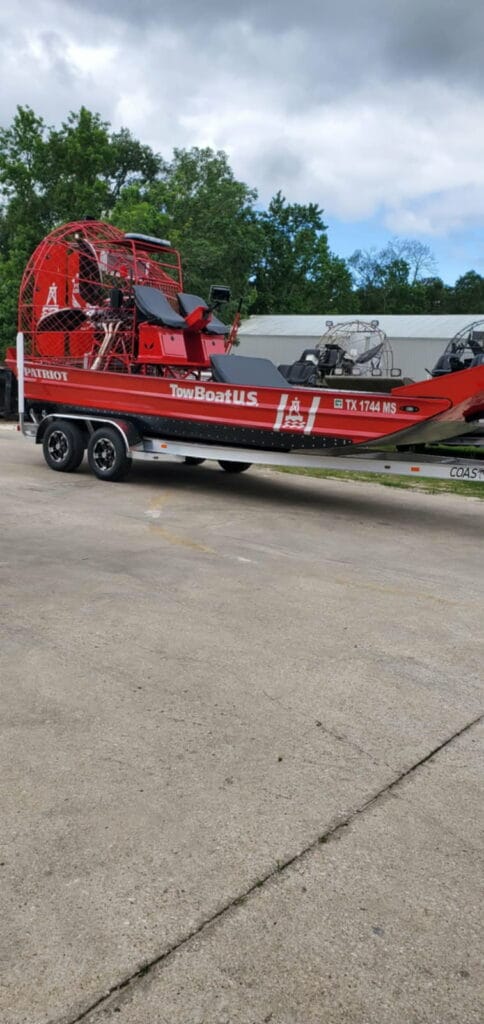 A red towing airboat on its trailer