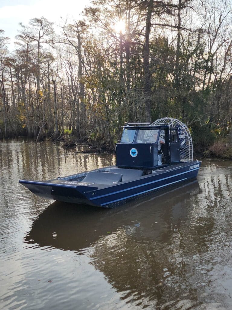 A blue cabin airboat in the swamp
