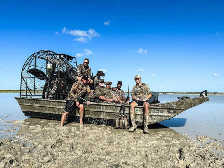 Hunters and their ducks on a mudflat