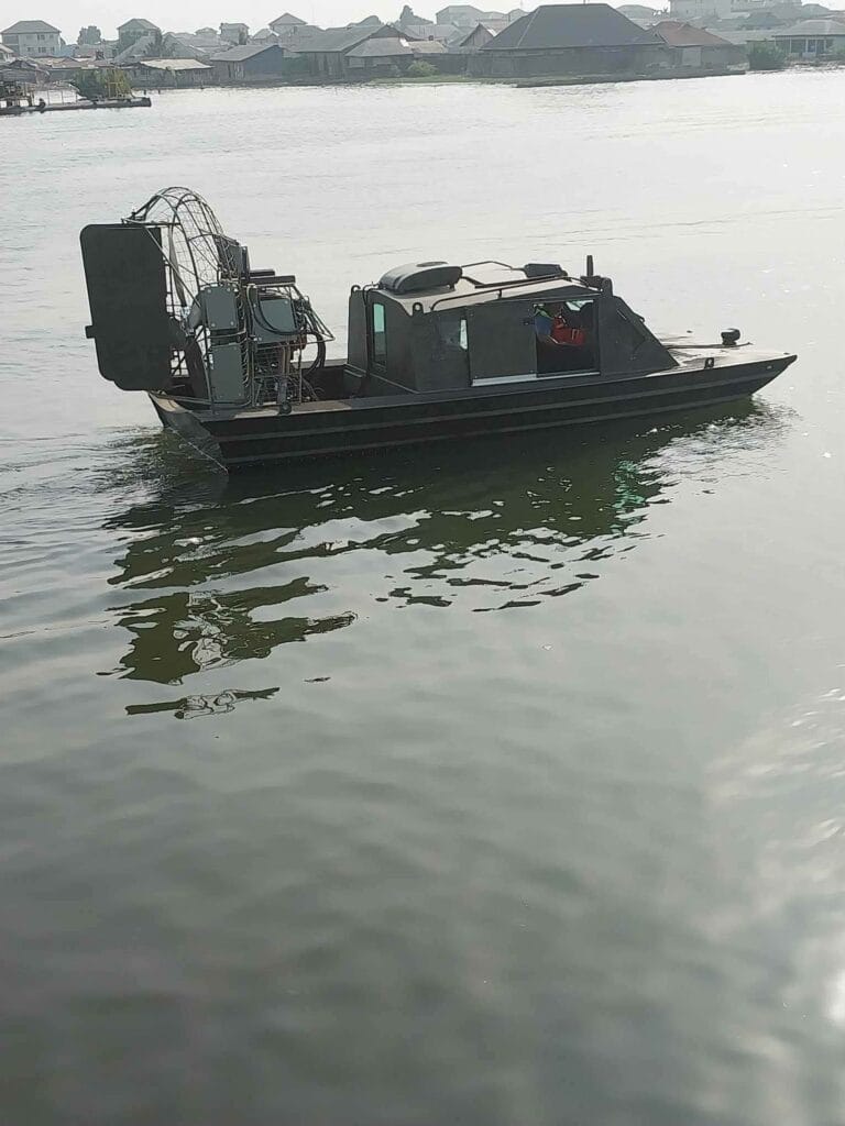 A dark cabin airboat on open water