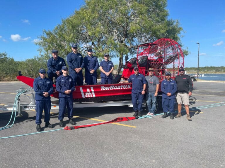 A towing crew lined up beside their new red Patriot