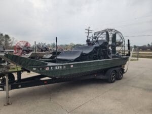 2018 AirRanger 20x9 airboat with a green hull and black seats on a tandem trailer