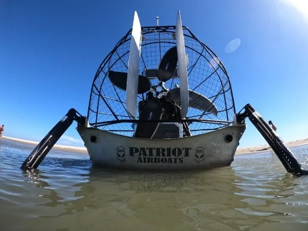 2023 Patriot airboat in shallow bay water with Power-Poles down, stern view