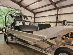 2023 Patriot 18x8 airboat on a Coastline trailer inside the shop, bow quarter