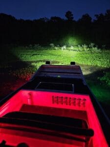 Red deck lights and a light bar on the marsh at night, seen from a 2023 Patriot airboat