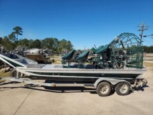 2002 Diamondback 20x8 airboat with green high seats on a tandem trailer, side view