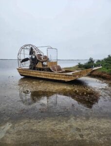 2018 AirRanger airboat parked on a shallow shoreline, front quarter view