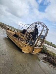 2018 AirRanger airboat on a mudflat, rear quarter view of the cage and seats
