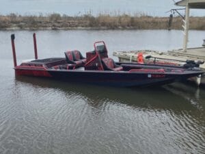 2019 Swamp Shark 24x7 mud boat in black and red, tied at a dock