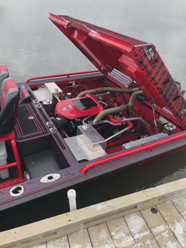 2019 Swamp Shark mud boat with the engine hatch open at the dock