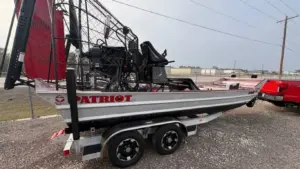 Airboat price guide: a 2025 Patriot 20x8 airboat on its tandem trailer at the Patriot shop in Vidor, Texas