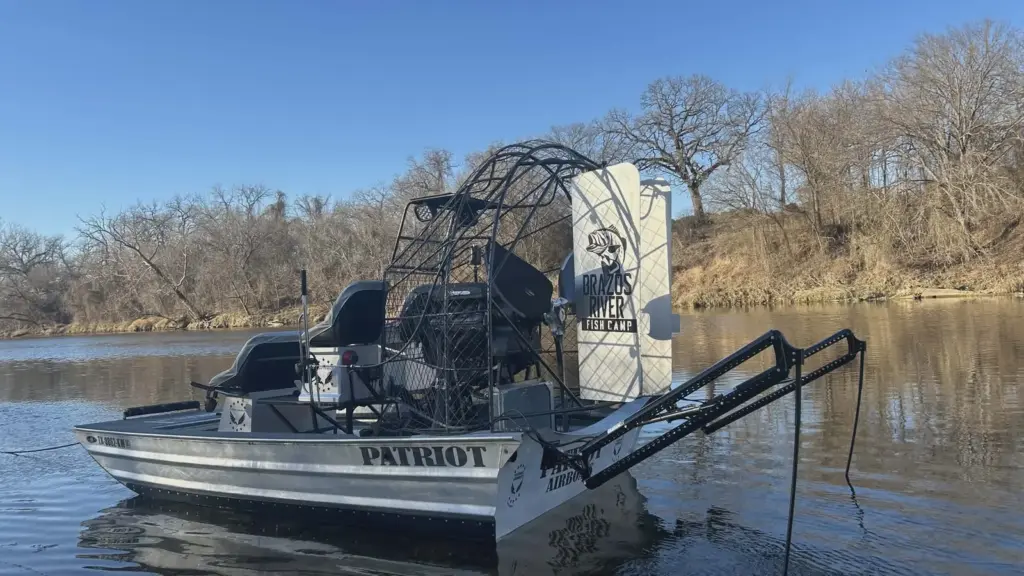 Airboat value guide: a Patriot airboat with a raised deck and rails tied up on a Texas river