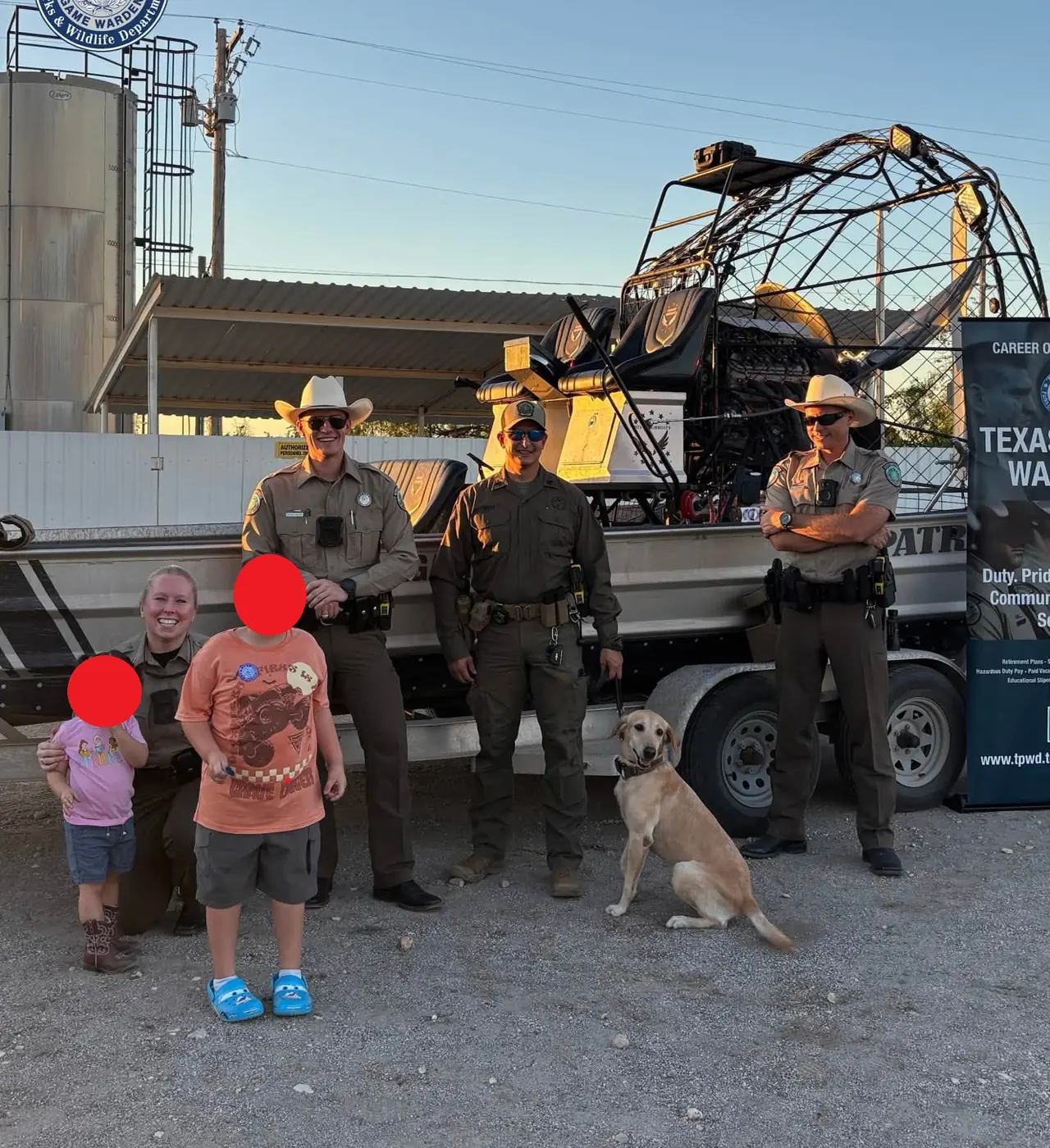 Texas Game Wardens and a K9 with visitors in front of a trailered Patriot airboat at the meet and greet