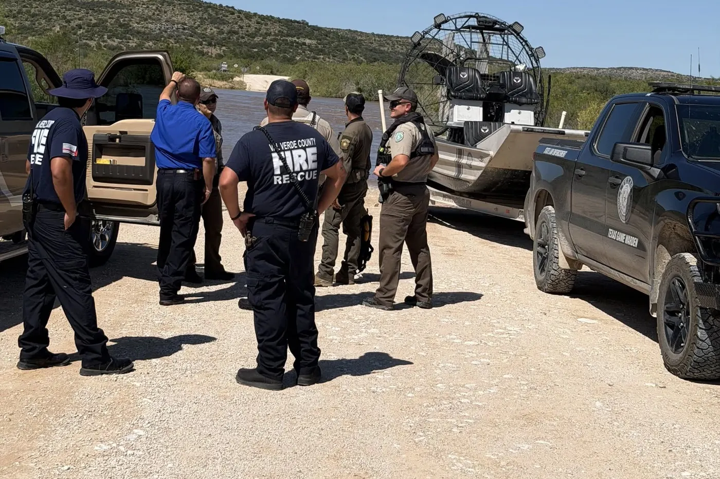 Val Verde County Fire Rescue crew and Texas Game Wardens standing beside a trailered Patriot airboat at the Dolan Creek Road crossing